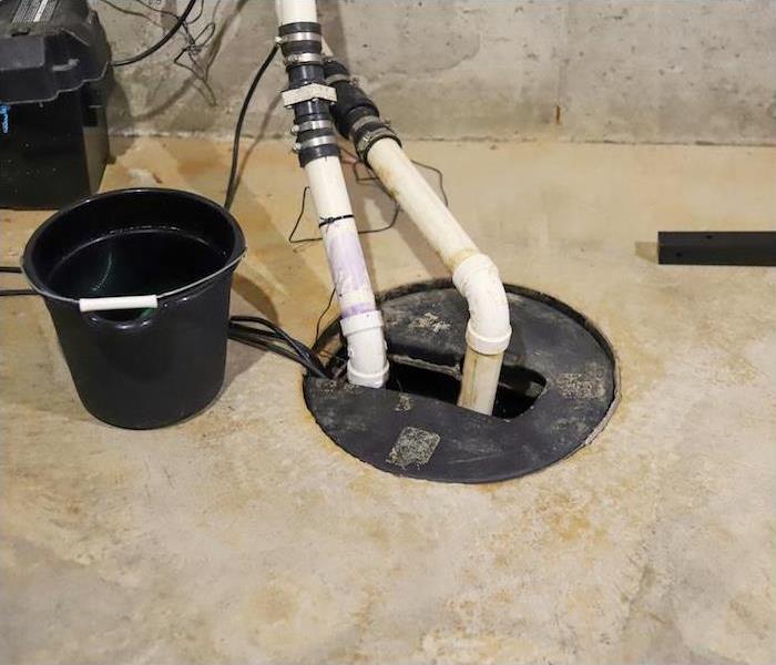 a sump pump in a concrete basement showing signs of not working