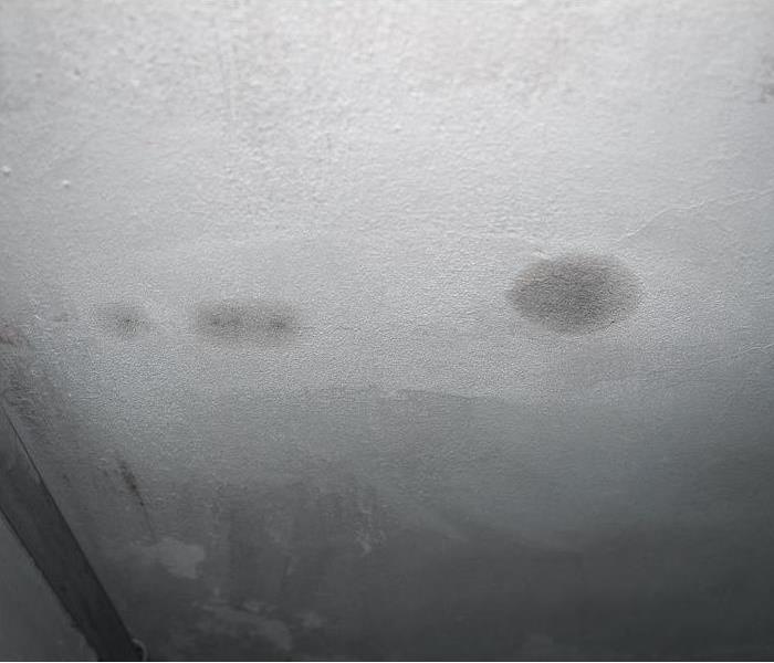a white drywall ceiling showing signs of water damage and spotting